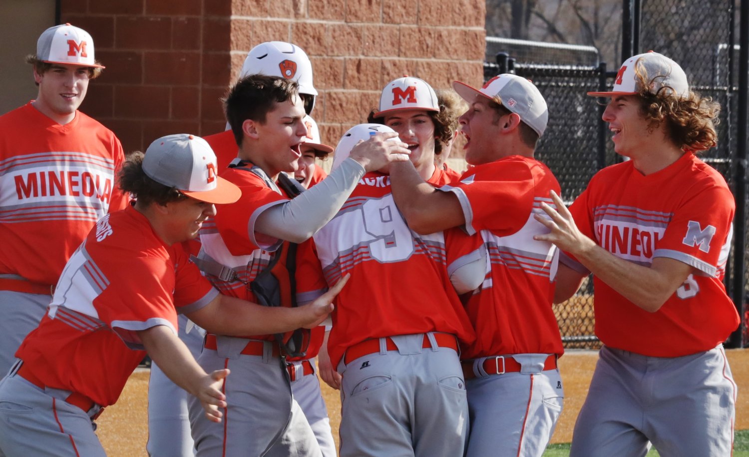 Yellowjacket Caleb Redding (9) gets mugged by teammates after crushing a solo home run to give Mineola the lead over Van last Friday.